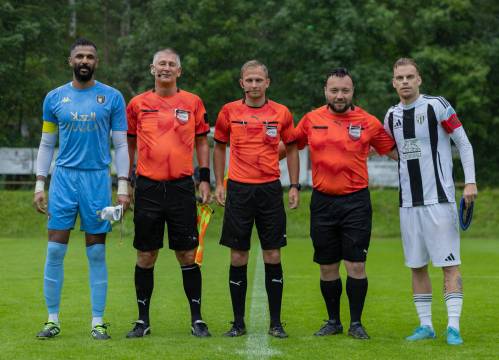 Kapetana s sodniško trojko. Skrajno desno je Aljaž Antolin. Tekma je potekala v deževnem vremenu.